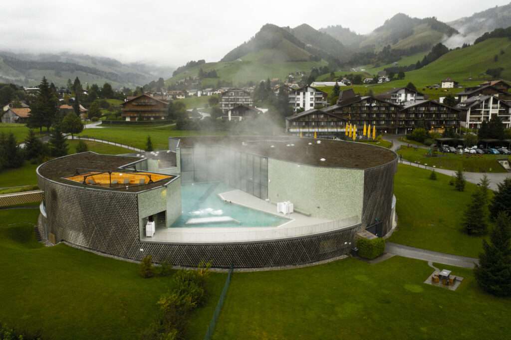 The beautiful and modern circular building of Bains de la Gruyere with panoramic views on the mountains
